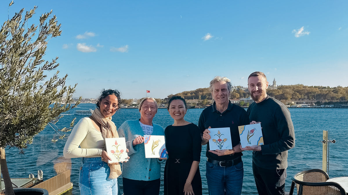Group of people holding ceramic painted tiles, background view is Bosphorus strait view 