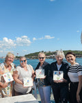 Group of people holding ceramic square tiles and smiling at the camera